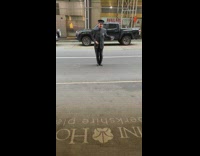 Doorman dancing in the street in front of apartment 