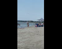 Two bikini girls squat in sync beach 