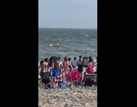 Bunch of people partner dance to music for beach video 