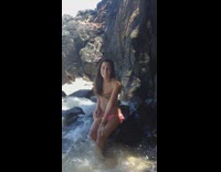 Girl sitting on rock big wave 