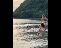 Three women in bikini poses at beach