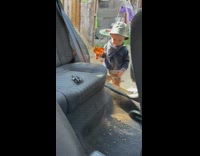 Little boy puts dirt into car while mom cleans it