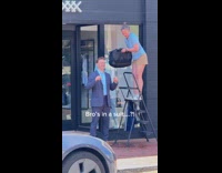 Man in suit ice bucket challenge outside store