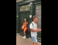 Woman orange dress stand outside Anne Franks house