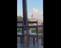 Man and woman takes picture of their pet dog beach rocks