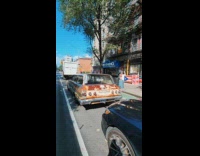 Rusty car parked on street window text