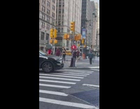 Guy dressed as clown with red hair on sidewalk 