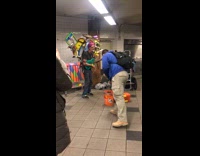 Guy plays guitar with drums on back in subway station