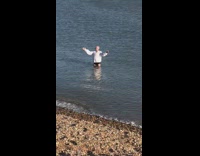 Old man white sleeves slow submerge beach