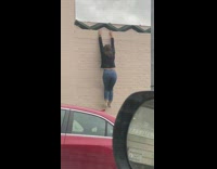 Girl hangs off wall for a photo 