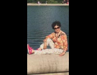 woman sits edge lake white house