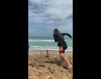 man woman flip kid sand beach