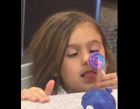 Young girl crossed eye lick sucker lollipop