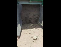 Sand sifting out of the back of an industrial construction vehicle 
