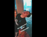 Guy fly emirates shirt sleeping on orange street block wooden pole