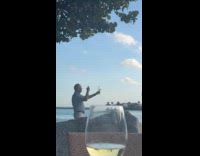 Man takes photo of wine at seaside
