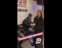 Guy drinks milk and pours cereal into his mouth in subway station