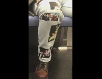 Scenes from Titanic the movie printed on mans pants on subway train