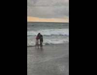 Boyfriend holds womans hand beach for picture