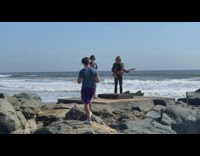 Guy yellow electric guitar brown jacket beach 