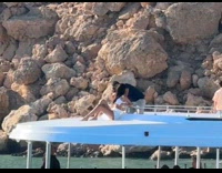 Woman beach wear poses on boat roof