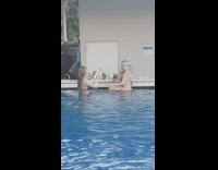 Girl poses in pool bottles of alcohol 