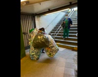 Lady carries huge bags of cans down stairs 