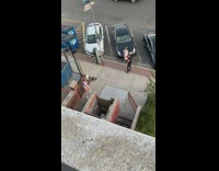 Purple shirt girl poses blue dumpster sidewalk 