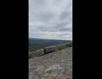 Mountain view trees clouds overcast large boulder