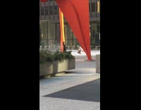 Girl stands under giant red sculpture 