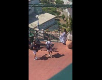 Woman white floral dress throws hat towards photographer