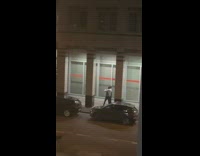 Two guys pose between pillars night car