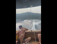 Guy rides wakeboard behind boat falls