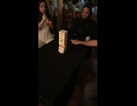 Guy chops off bottom jenga block row with hand and lands it