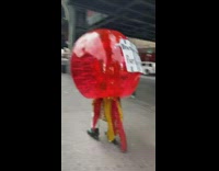 Red inflatable ball guy rollerblades handwritten sign