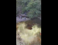 Guy poses in water waterfall green smoke 
