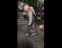 man on all fours being walked by woman in costume