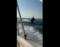 Two men on inflatable pulled by boat