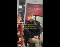 Man Waits Patiently for his Lady inside Boutique