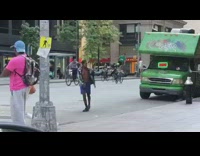Green shirt guy stands rides bicycle car