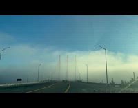Filmer drives on bridge full of fog