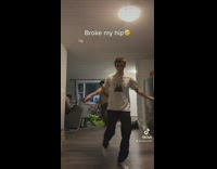 Man Dances while Two Men Fix Couch