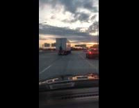 Man rides on the back of 18 wheeler truck on freeway 