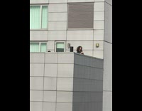 Man with curly hair solves Rubiks cube on the balcony