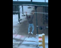 Man scaffolding pull-ups outside the snowy sidewalk