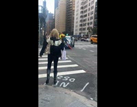 Woman carries parrot while crossing the road