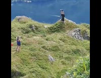 Black shorts guy headstand grass mountain water