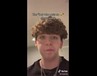 Guy black shirt curly hair tiktok cross earrings