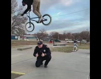 Guy jumps bicycle over police officer skatepark 