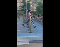 Guy exercises legs while balancing trashcan on head 